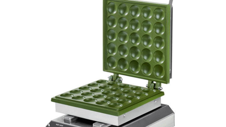 Modern bir mutfakta tezgâh üzerinde yer alan, pişirme esnasında pankek dolu bir pankek makinesi.