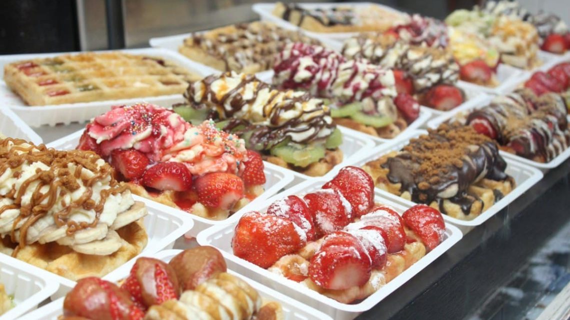 Brüksel waffle makinesi ile altın rengi ve çıtır çıtır Belçika waffle'ları hazırlanıyor.